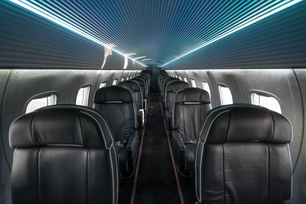 Interior regional aircraft conversion on Embraer aircraft - photo of brightly lit aircraft aisle with one seat on either side
