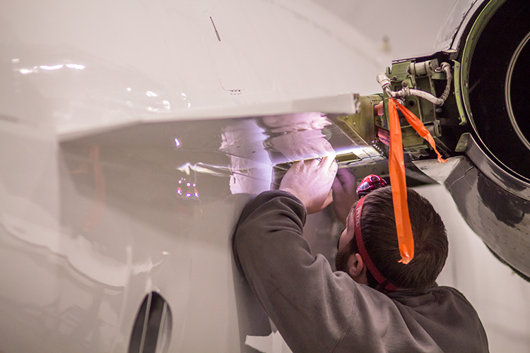 Aircraft technician inspecting a BeechJet aircraft 