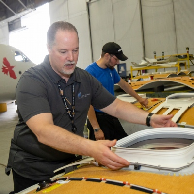 Interior regional aircraft conversion on Embraer aircraft - photo of workers assembling ceiling parts of an aircraft
