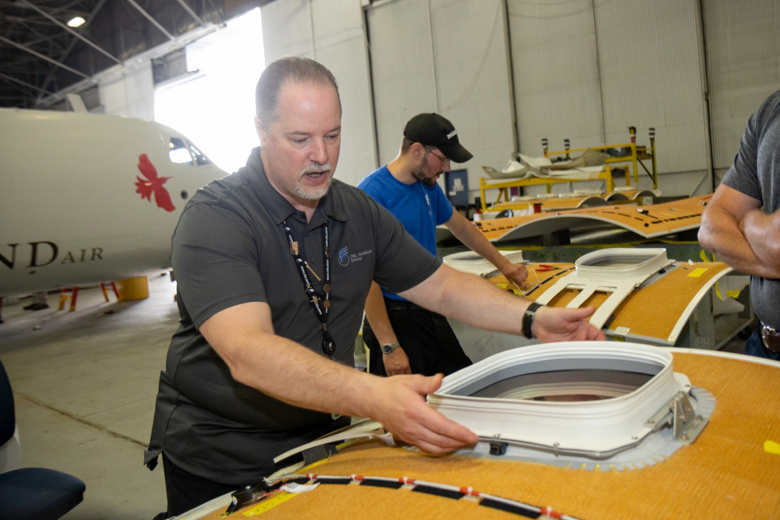 Interior regional aircraft conversion on Embraer aircraft - photo of workers assembling ceiling parts of an aircraft