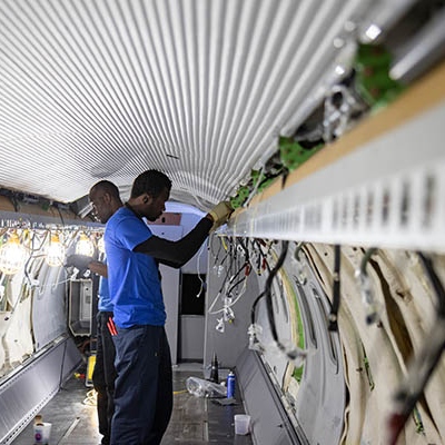 Interior regional aircraft conversion on Embraer aircraft - photo of two technicians working on the wiring inside an aircraft cabin